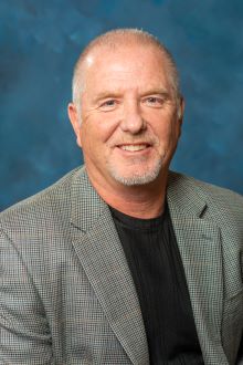 male with grey blazer and black shirt
